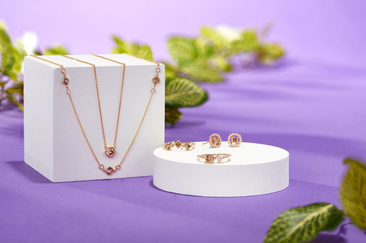 brown diamond jewelry on display with a purple background