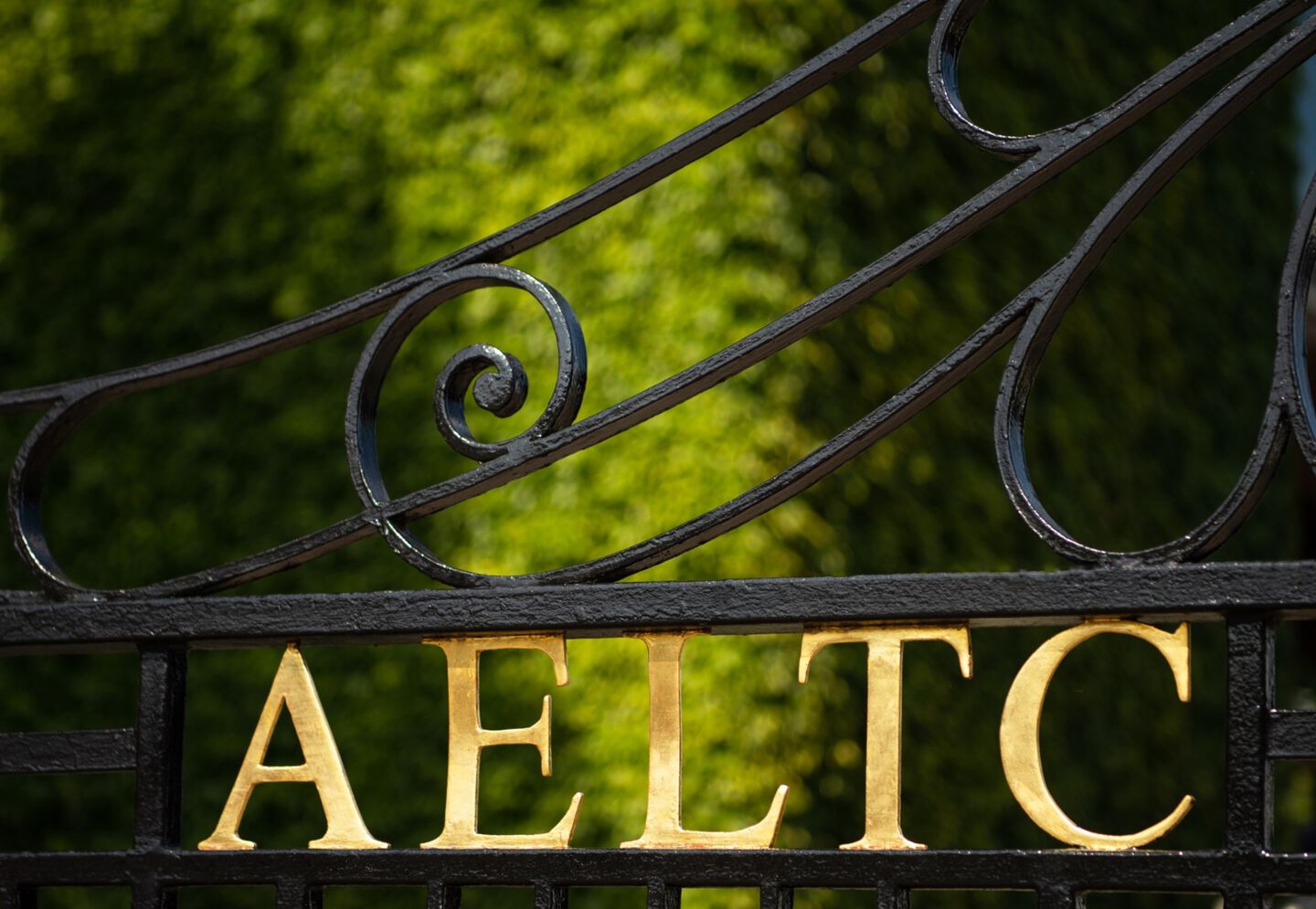 Iron fence with the letters AELTC in gold.